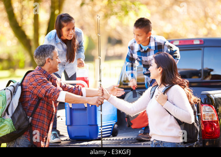 Family Unpacking Pick Up Truck On Camping Holiday Stock Photo