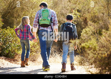 Rear View Of Father And Children Hiking In Countryside Stock Photo