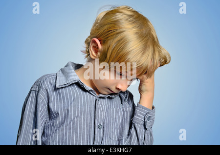 Young depressed boy on blue background Stock Photo