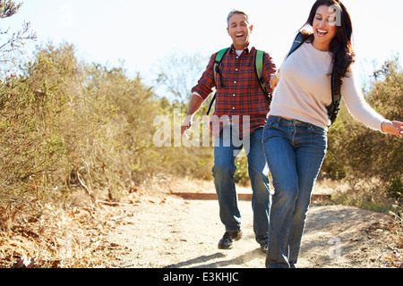 Couple Hiking In Countryside Wearing Backpacks Stock Photo