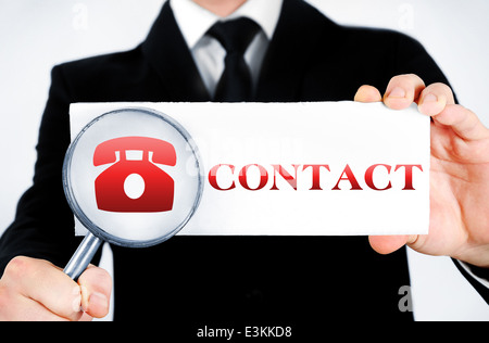 Business man magnifying contact word Stock Photo