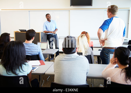 Male Tutor Teaching University Students In Classroom Stock Photo