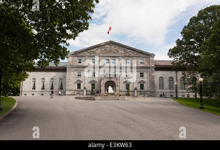 Rideau Hall Main Entrance. Tourists mill about or just wait outside the front of Rideau hall. Flags are at half mast. Stock Photo