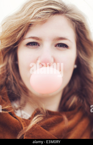 Portrait of teenage girl (13-15) blowing chewing gum bubble Stock Photo