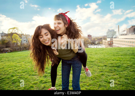 Young woman giving piggyback ride to her friend
