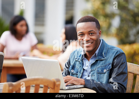 Male University Student Working On Project Outdoors Stock Photo