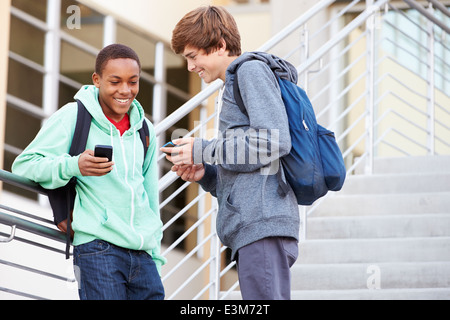 Two High School Students Outside Building With Mobiles Stock Photo