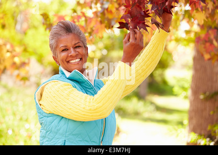 Mature Woman Relaxing In Autumn Landscape Stock Photo