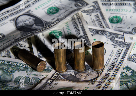 Bullet casings on a pile of American one dollar bills Stock Photo