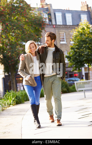 Young Couple Walking Through City Park Together Stock Photo