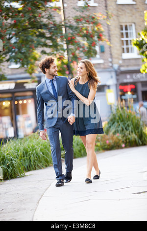 Young Business Couple Walking Through City Park Together Stock Photo