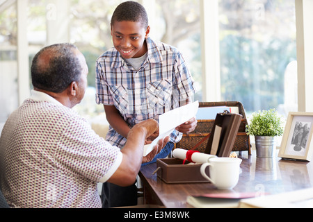 Grandfather Showing Document To Grandson Stock Photo