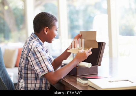 Boy Looking At Letter In Keepsake Box On Desk