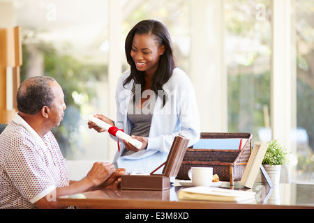 Senior Father Discussing Document With Adult Daughter Stock Photo