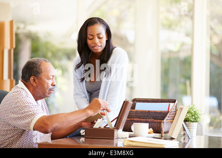 Senior Father Discussing Document With Adult Daughter Stock Photo