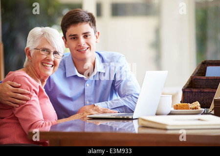Teenage Grandson Helping Grandmother With Laptop Stock Photo
