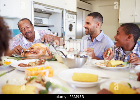 Multi-Generation Family Sitting Around Table Eating Meal Stock Photo