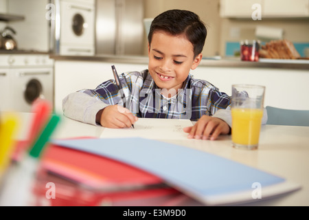 Hispanic Boy Doing Homework At Table Stock Photo