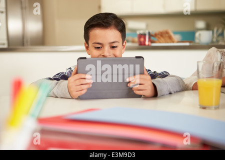 Boy Using Digital Tablet To Do Homework Stock Photo