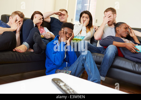 Group Of Friends Watching Television At Home Together Stock Photo