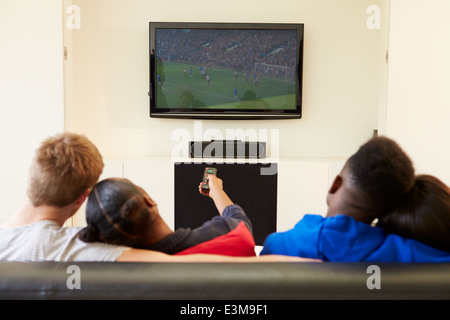 Two Young Couples Watching Television At Home Together Stock Photo