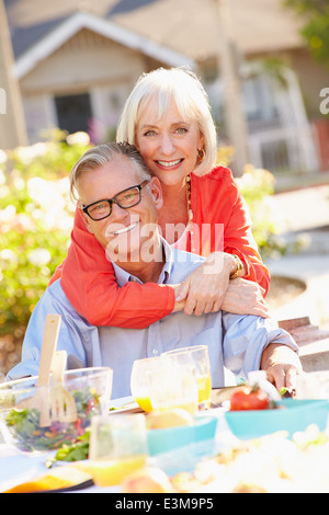 Mature Romantic Couple Enjoying Outdoor Meal In Garden Stock Photo