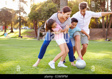 Family Playing Soccer In Park Together Stock Photo