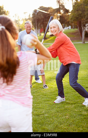 Grandparents Playing Baseball With Grandchildren In Park Stock Photo