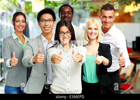 Cheerful business group giving thumbs up Stock Photo