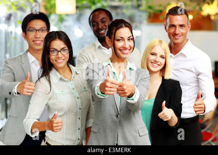 Happy business group giving thumbs up Stock Photo