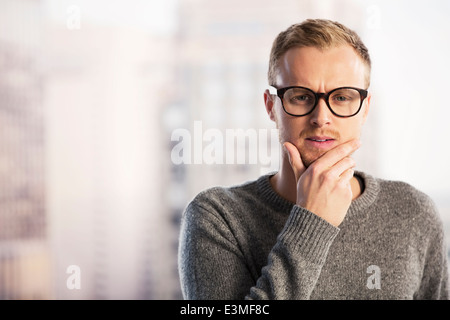Pensive businessman with hand on chin Stock Photo