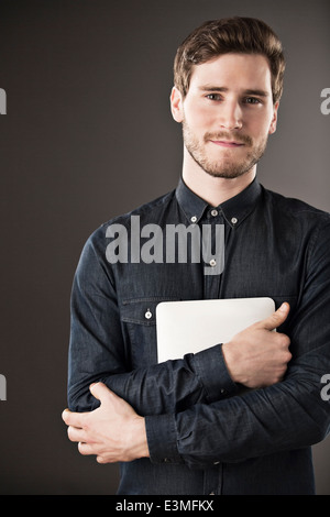 Portrait of serious businessman holding digital tablet Stock Photo