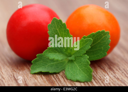 Round Chewing gum with green stevia on wooden surface Stock Photo