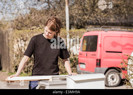 Female carpenter examining wooden plank outdoors Stock Photo