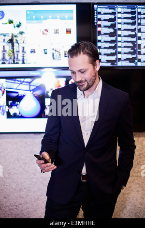 Mid adult businessman using mobile phone in office Stock Photo