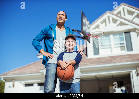 Father and son with basketball in driveway Stock Photo