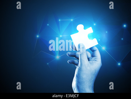 A man holding the correct piece of the puzzle. Stock Photo