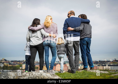 Full length rear view of homosexual families standing at lakeshore Stock Photo