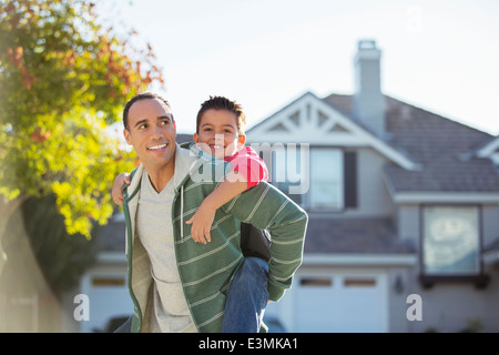 Father piggybacking son outdoors Stock Photo