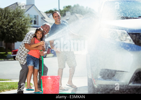 Multi-generation family washing car in driveway