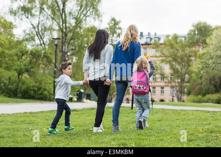 Rear view of female homosexual family walking in park Stock Photo