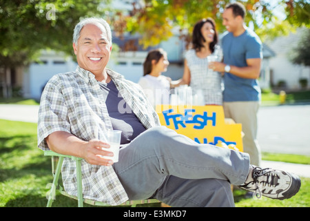 Portrait of smiling man drinking lemonade near lemonade stand Stock Photo