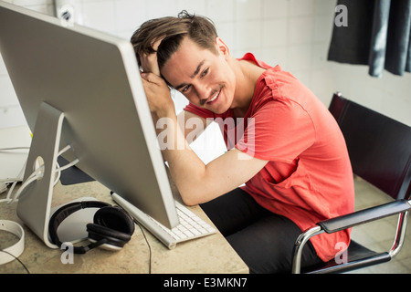 Thoughtful young businessman at computer desk in new office Stock Photo