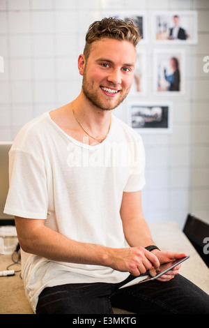 Portrait of happy young businessman using digital tablet in new office Stock Photo