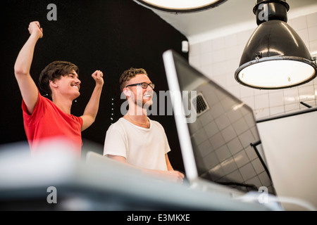 Happy young business people celebrating success in new office Stock Photo