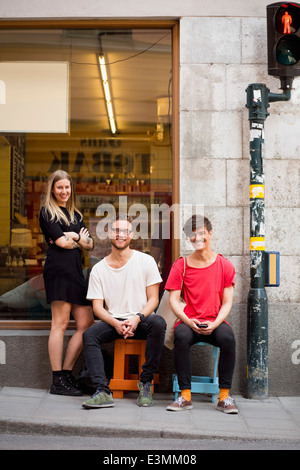 Full length portrait of happy young friends on sidewalk Stock Photo