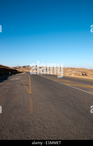 tarried road with yellow markings running through rural landscape Stock Photo