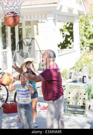 Grandfather and granddaughters playing basketball Stock Photo