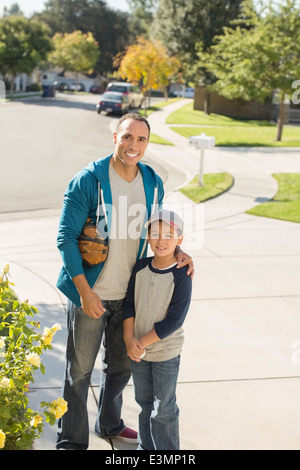 Portrait of smiling father and son in driveway Stock Photo