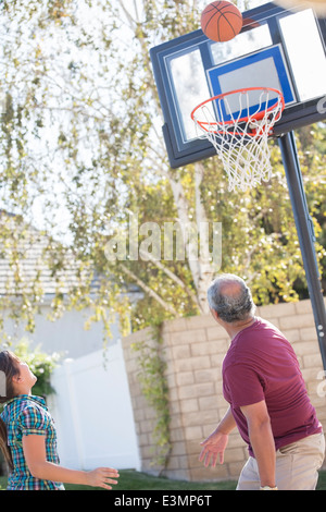 Grandfather and granddaughter playing basketball Stock Photo